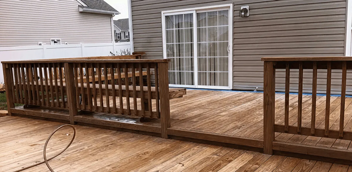 Deck sealing service protecting a backyard wood deck and railings in Manchester, NH