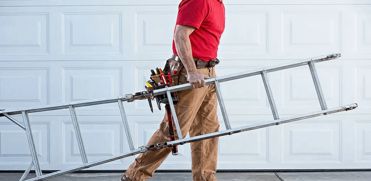 Garage door repair technician arriving with tools and ladder in Manchester, NH