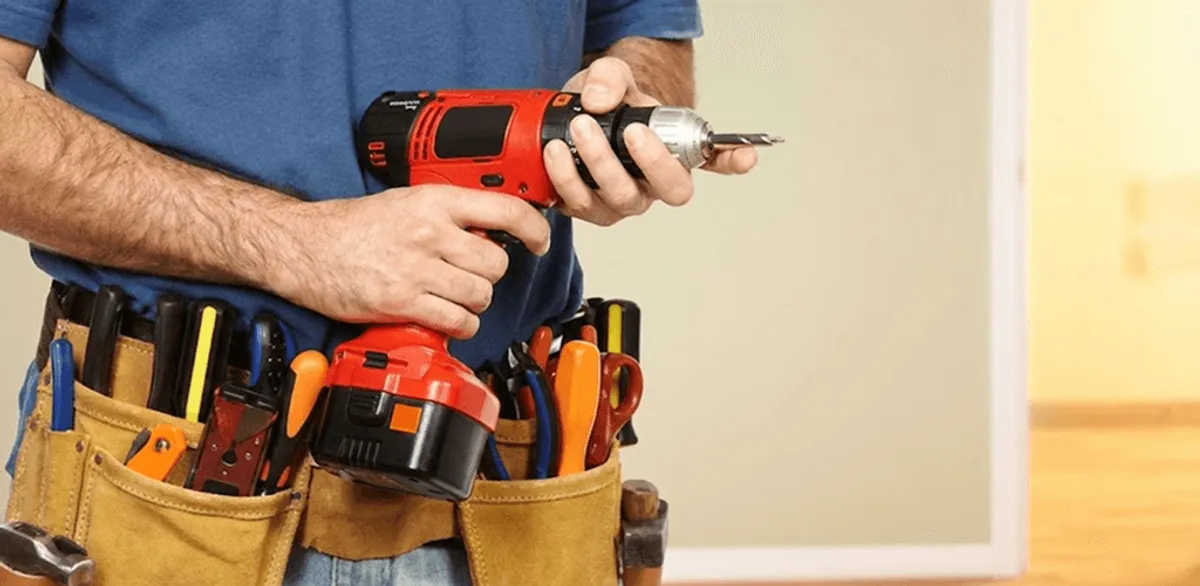 Handyman holding a power drill for home repairs and installations in Manchester, NH