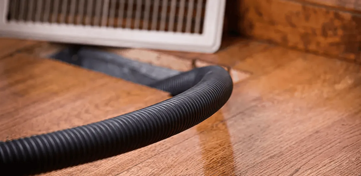 Air duct cleaning hose inserted into a floor vent for ductwork cleaning in Manchester, NH